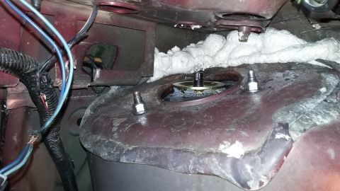 2000 Pontiac Grand Prix - Close-up view of a vehicle's engine bay, focusing on the strut mount area with visible wiring and insulation.