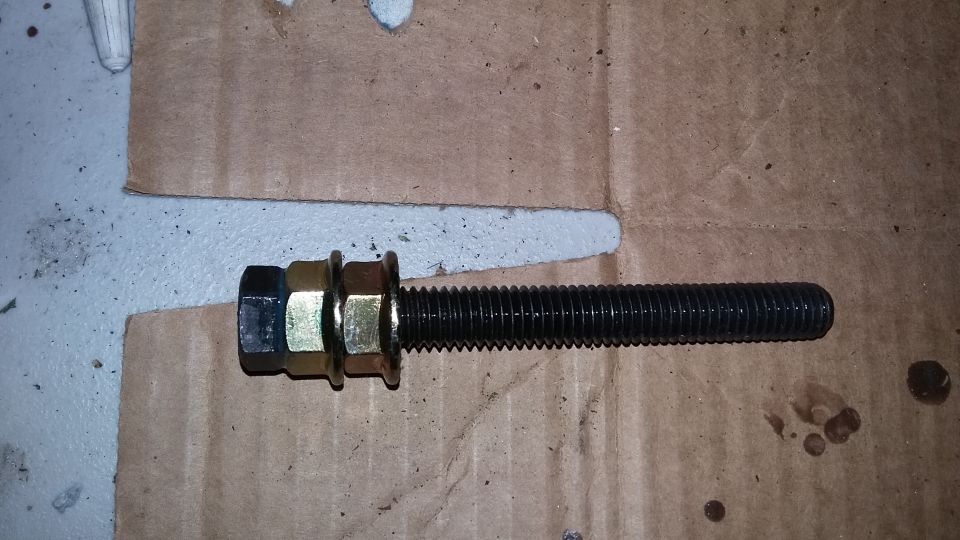 Bolt with two nuts and washers on cardboard