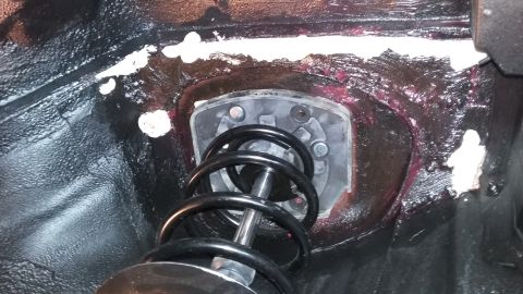 2000 Pontiac Grand Prix - Close-up of a vehicle's suspension strut mount, showing the coil spring and mounting hardware.
