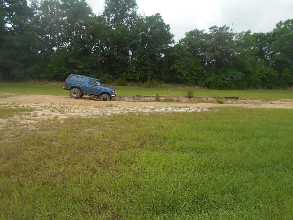 Blue 1992 Ford Bronco stuck in mud, side view