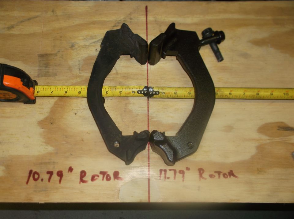 Two brake caliper brackets measured with a tape measure. One is labeled 10.79" Rotor, the other 11.79" Rotor