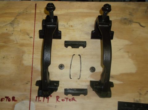 1979 Ford Ranchero - Brake caliper parts are arranged on a wooden surface with handwritten labels.