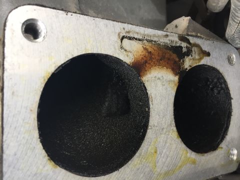 1996 Ford Bronco - This image shows the heavily carbon-fouled intake ports of an engine part.