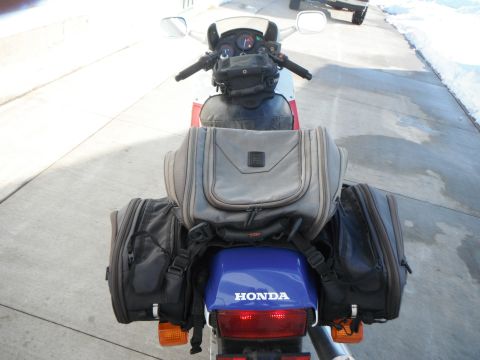 1989 Honda CBR600F - A motorcycle is equipped with extensive luggage for touring, viewed from directly behind.