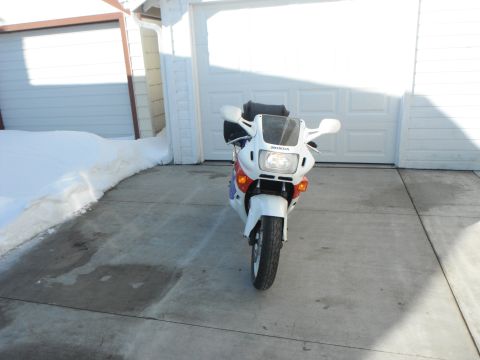 1989 Honda CBR600F - Front view of a white 1989 Honda CBR600F motorcycle parked in front of a garage with snow on the side.