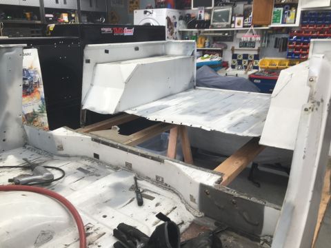 1992 Jeep Wrangler - The interior of a vehicle is shown with parts removed and supported by wooden beams, indicating ongoing repair or modification.