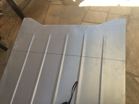 1992 Jeep Wrangler - A gray metal panel with embossed lines and a black strap is shown, likely a vehicle part.