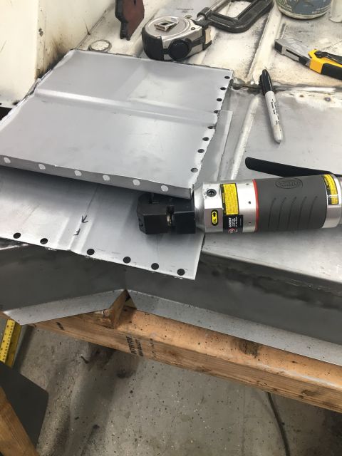 1992 Jeep Wrangler - A close-up of sheet metal being prepared for repair with a punch tool and marker.