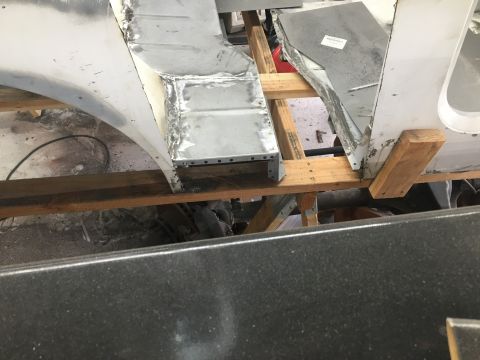 1992 Jeep Wrangler - Close-up view of vehicle body repair work, focusing on patched metal sections and structural supports.
