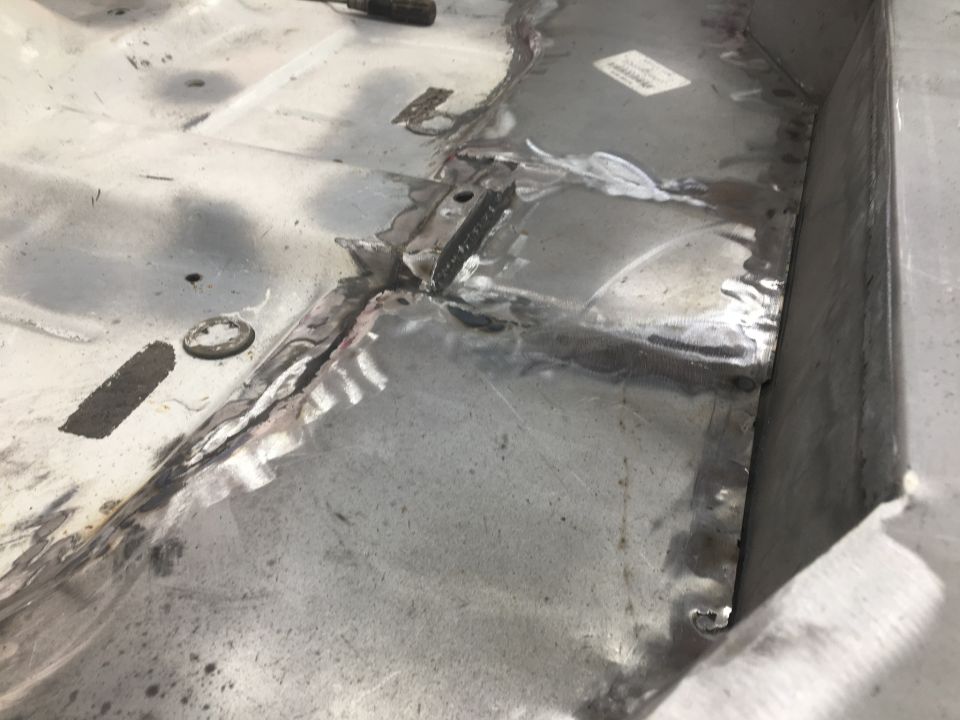 Welded metal floor pan with patches and some rust
