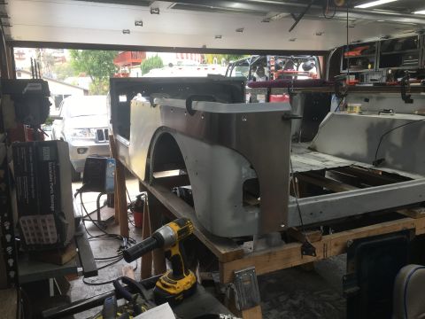 1992 Jeep Wrangler - Jeep CJ body tub is being worked on in a garage, with another Jeep in the background.