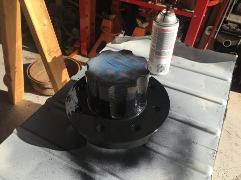 1992 Jeep Wrangler - A black painted hub assembly sits on a metal surface next to a can of spray paint.