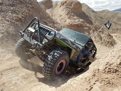 1992 Jeep Wrangler - A modified 1992 Jeep Wrangler navigates a steep, dusty off-road trail.