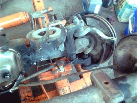 1978 Ford Bronco - Close-up of a vehicle's front suspension and brake system, likely undergoing maintenance or awaiting repair.