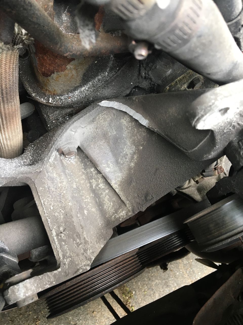 Engine bracket and pulley system with ribbed belt