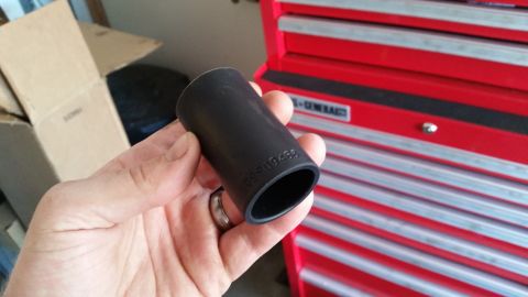 1985 Ford Bronco - A socket wrench part is held in a hand with a red toolbox in the background.