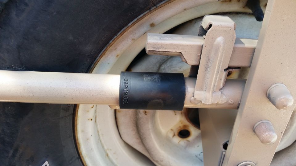Close-up of a spare tire mount with a socket on a bar. Text on socket reads 09P0946