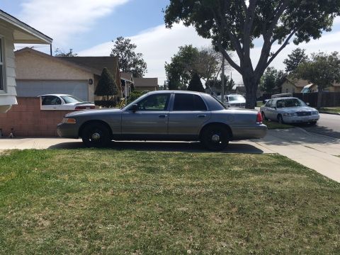 1989 Mazda MX-6 - A gray sedan sits on a lawn with another car visible in the background on the street.