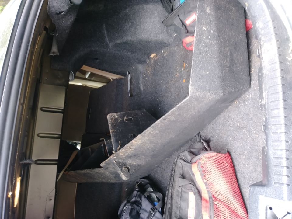 Interior of a vehicle's cargo area with some storage boxes and bags