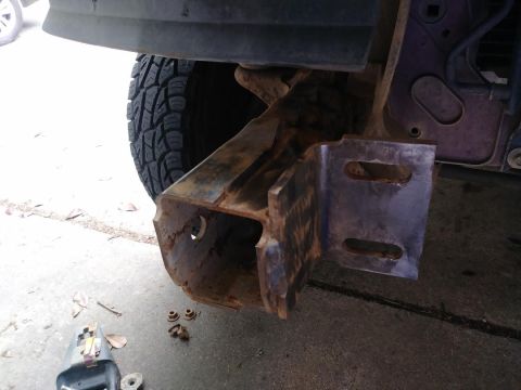 1996 Ford Bronco - Close-up view of a rusted bumper bracket and tire, suggesting a repair or modification is underway.