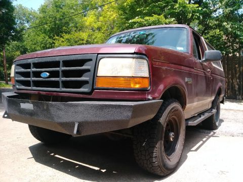 1996 Ford Bronco - A red 1996 Ford Bronco is shown with a custom aftermarket bumper installed.