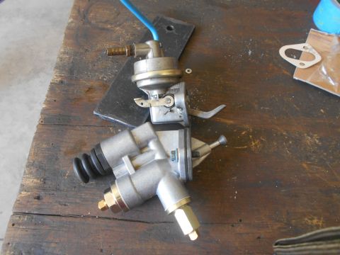 1992 Ford Bronco - Two mechanical fuel pumps are laid out on a wooden surface, possibly for repair or replacement.
