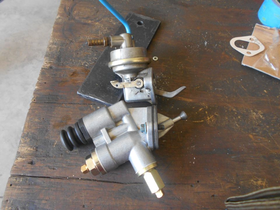 Two mechanical fuel pumps on a wooden workbench