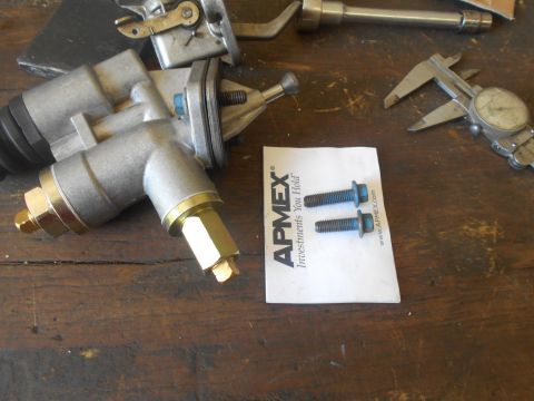 1992 Ford Bronco - A fuel pump assembly and two bolts are laid out on a wooden surface, alongside a caliper and other mechanical parts.