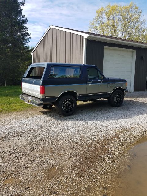 1987 Ford Bronco - This 1987 Ford Bronco is parked in front of a garage on a cloudy day.