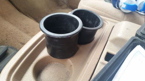 1985 Ford Bronco - Close-up of the interior cup holders, showing their placement within the vehicle's console.