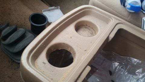 1985 Ford Bronco - Center console part with cup holders and gear shift boot visible.
