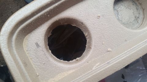 1985 Ford Bronco - This is a close-up view of a vehicle's interior cup holder, showing its textured surface and a central opening.