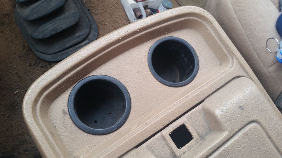 Center console with two cup holders and a gear shift boot. A SuperMotors logo is in the corner