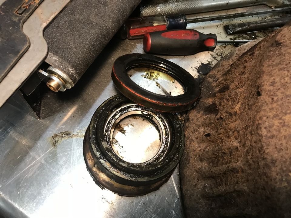 Greasy bearing seals and some tools on a metal surface. Supermotors.net logo visible