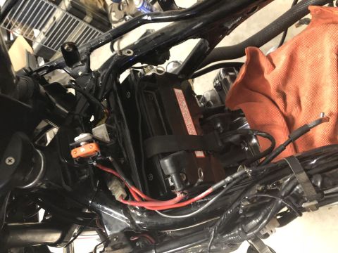 1983 Yamaha Venture - Close-up view of a motorcycle's battery and electrical wiring, including an orange fuse holder.