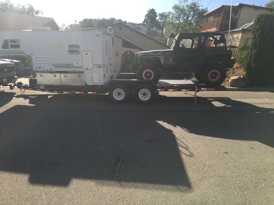 1992 Jeep Wrangler on a dual-axle trailer, loaded behind a camper