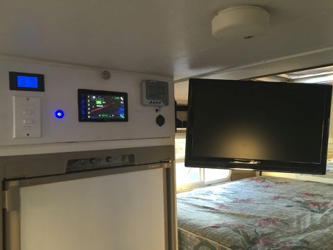 1992 Jeep Wrangler - The interior of an RV shows a television, stereo system, and refrigerator.