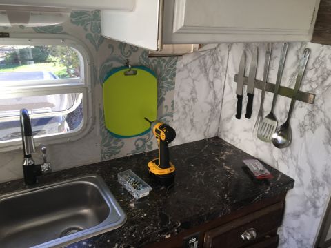 1992 Jeep Wrangler - Interior view of an RV kitchen, showing a sink, countertop, and various kitchen tools.