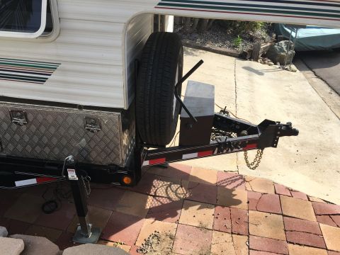 1992 Jeep Wrangler - This image shows the rear of a trailer, a spare tire, a diamond plate storage box, and the hitch mechanism.
