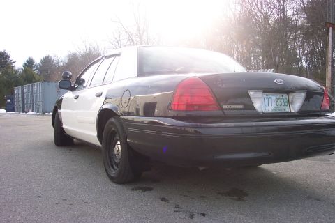 2001 Ford Crown Victoria - Rear view of a black and white 2001 Ford Crown Victoria police car parked outdoors.