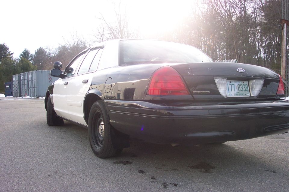 2001 Ford Crown Victoria police car, rear 3/4 view, black and white paint scheme