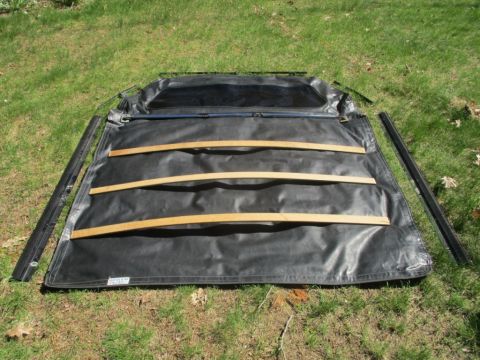 1996 Ford Bronco - This is a soft top for a vehicle, laid out on the grass with its support rails.