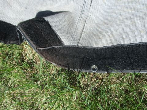 1996 Ford Bronco - The edge of a car cover, showing its construction and material, lies on the grass.