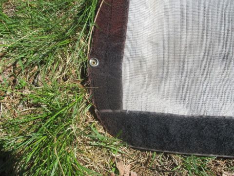 1996 Ford Bronco - Detail of a soft top cover, showing its construction with mesh fabric, reinforced edges, grommets, and velcro fasteners.