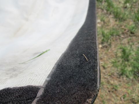 1996 Ford Bronco - Detail of fabric edge with velcro fastener, outdoors with grass visible.