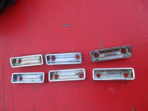 1996 Ford Bronco - A collection of chrome trim pieces, likely for a vehicle, are displayed on a red background.