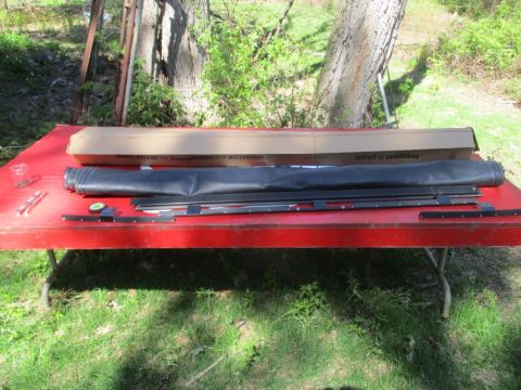 1996 Ford Bronco - Parts for a soft top are laid out on a table, with a box and metal pieces visible.