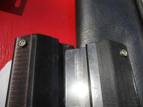 1996 Ford Bronco - Close-up view of two black textured plastic trim pieces, each secured with a silver screw.