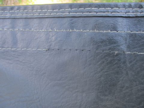 1996 Ford Bronco - Close-up view of the stitching on a black soft top, showing some wear and tear.