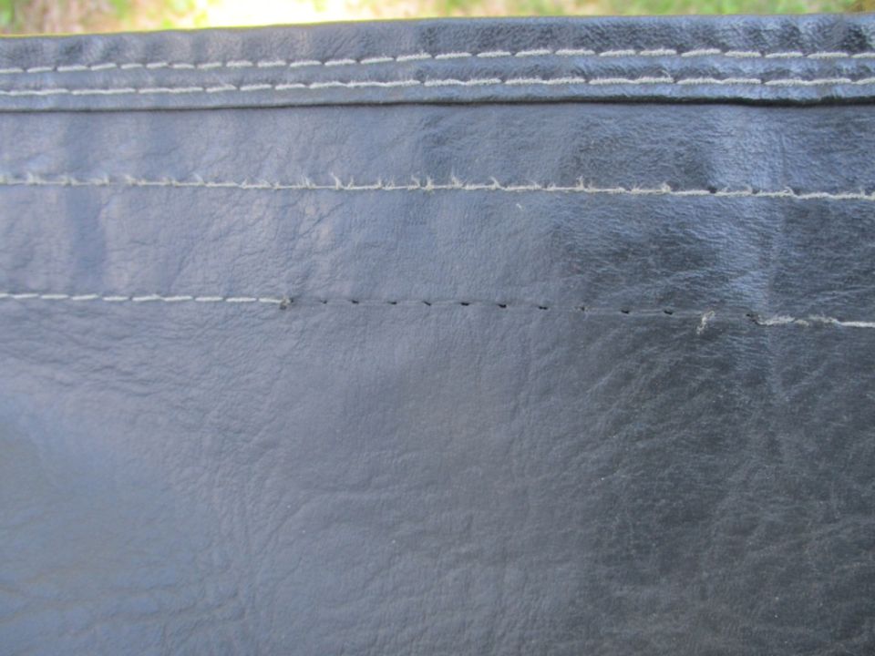 Black soft top with white stitching and a small tear